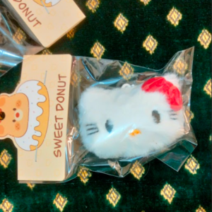 A collection of colorful, assorted mini plush keychain charms arranged neatly, individually packaged.