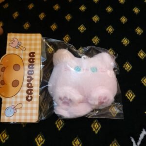 A collection of colorful, assorted mini plush keychain charms arranged neatly, individually packaged.