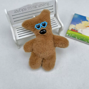 A collection of classic brown plush teddy bear keychains in various quirky styles attached to a bag.