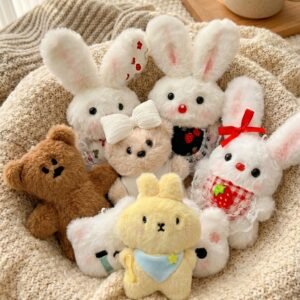 A soft plush character keychain with a built-in squeaker attached to a bag strap.