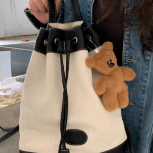 A collection of classic brown plush teddy bear keychains in various quirky styles attached to a bag.