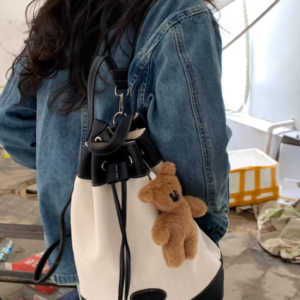 A collection of classic brown plush teddy bear keychains in various quirky styles attached to a bag.