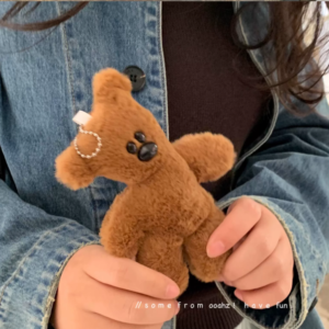 A collection of classic brown plush teddy bear keychains in various quirky styles attached to a bag.