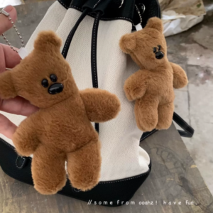 A collection of classic brown plush teddy bear keychains in various quirky styles attached to a bag.