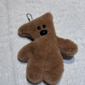 A collection of classic brown plush teddy bear keychains in various quirky styles attached to a bag.
