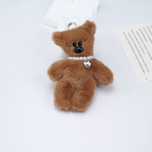 A collection of classic brown plush teddy bear keychains in various quirky styles attached to a bag.